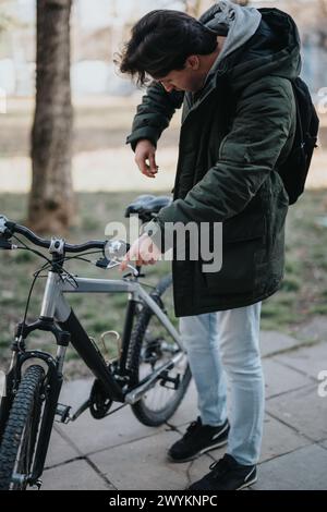 Young man checking bicycle before a ride in an urban park Stock Photo