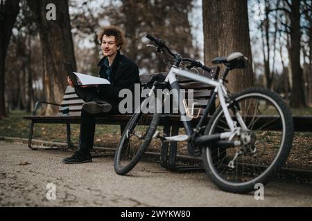 Young business entrepreneur with a bicycle reviewing documents in the park Stock Photo