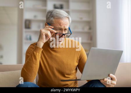 Mature man using laptop at home with a concentration Stock Photo