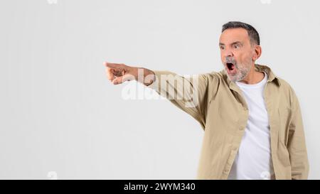 Shocked senior man pointing with an open mouth Stock Photo