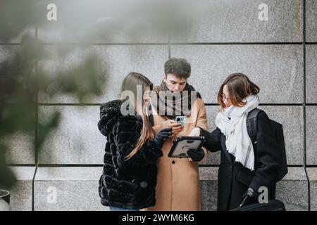 Professional business teammates of young colleagues using tech on snowy city day. Stock Photo
