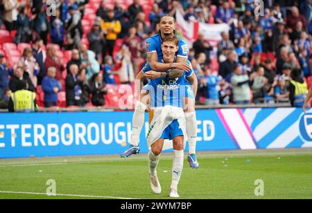 Peterborough United's Hector Kyprianou celebrates with team-mate Jadel Katongo (top) during the Bristol Street Motors Trophy final at Wembley Stadium, London. Picture date: Sunday April 7, 2024. Stock Photo