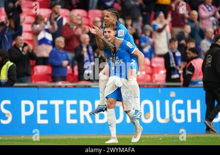 Peterborough United's Hector Kyprianou celebrates with team-mate Jadel Katongo (top) during the Bristol Street Motors Trophy final at Wembley Stadium, London. Picture date: Sunday April 7, 2024. Stock Photo