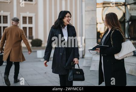 Two professional businesswomen having a friendly conversation outdoors. Stock Photo