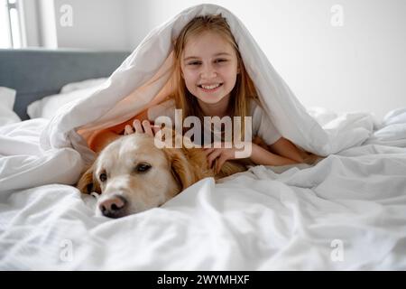 Girl Lies Under Blanket With Her Golden Retriever Dog Stock Photo - Alamy