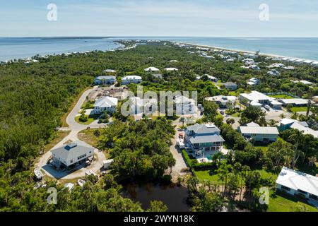 Wealthy neighborhood in small town Boca Grande, Florida with expensive waterfront houses between green palm trees. Development of US premium housing Stock Photo