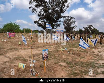 Israeli soldiers gather around flags and grave markers in a field in Re'im, southern Israel, where Hamas terrorists massacred some 325 Israelis attending the Nova music and dance party on October 7, 2023 near the Gaza Strip border, as family members and friends attend a memorial marking the six-month anniversary of the Hamas attack on October 7, 2024. Some 325 Israelis and foreigners were murdered by Hamas terrorists who broke through the border fence and attacked dozens of communities along the border on October 7. Photo by Jim Hollander/UPI Credit: UPI/Alamy Live News Stock Photo