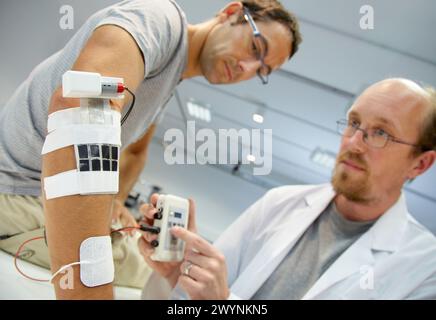 Researcher placing multipad electrodes in the control arm for the stimulation model for sensor signals Applications for rehabilitation of lower limb/ superior heart, SCI, Unit of Health Technology, Tecnalia Research & Innovation, Miramon Technology Park, San Sebastian, Donostia, Gipuzkoa, Basque Country, Spain. Stock Photo