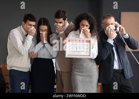 Business people with evacuation plan covering faces in burning office building Stock Photo