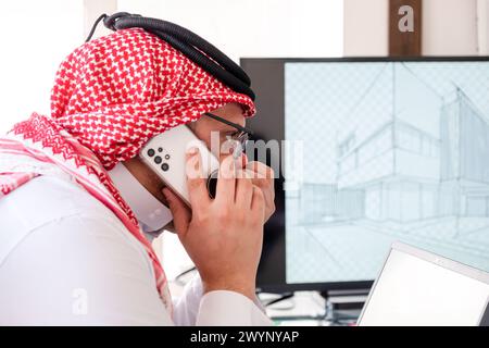arabic male using phone during work to make sure it is flow is in the right direction Stock Photo