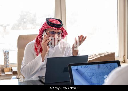 arabic male using phone during work to make sure it is flow is in the right direction Stock Photo