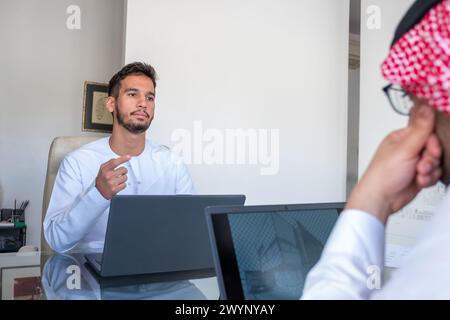 Arab talking while working on their project Stock Photo