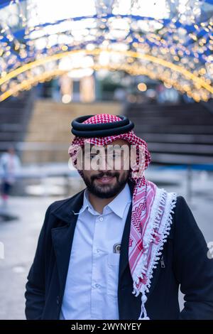 portrait for arabic young male wearing traditional clothes with modern background and blurred lights Stock Photo