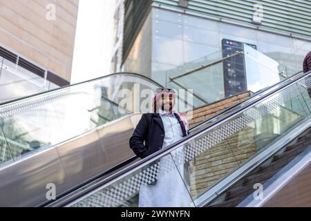 arabic man on escalator Stock Photo