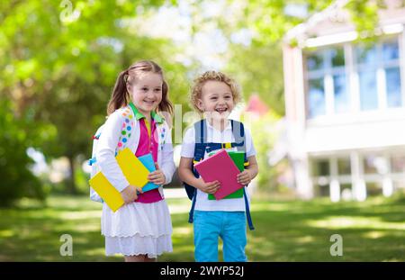 Children go back to school. Start of new school year after summer vacation. Boy and girl with backpack and books on first school day. Stock Photo