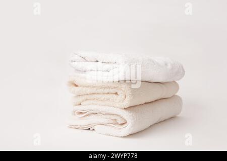 Clean beige soft bath towels stack on a white background Stock Photo