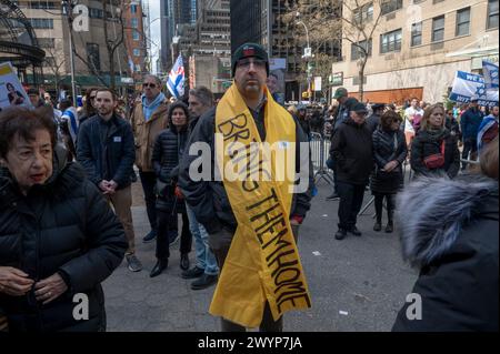 NEW YORK, NEW YORK - APRIL 07: A man with a yellow 'BRING THEM HOME' ribbon attends a 'Bring Them Home NOW' rally marking the six month anniversary of the attacks on Israel by Hamas and calling for the return of hostages held by Hamas, near the United Nations Headquarters on April 07, 2024 in New York, New York, USA. Israel marks six months since Hamas militants launched an attack against Israel from the Gaza Strip on the October 07 attacks, as 133 hostages are currently still being held captive in Gaza, according to the Israeli IDF. Stock Photo