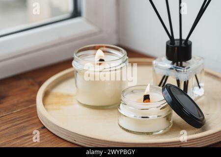 Scented Candles and Diffuser on a Wooden Tray by the Window Stock Photo