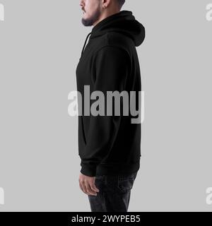 Template of black oversized hoodie on bearded man, side view, clothing with pocket, cuff, strings, isolated on background. Mockup of fashionable male Stock Photo