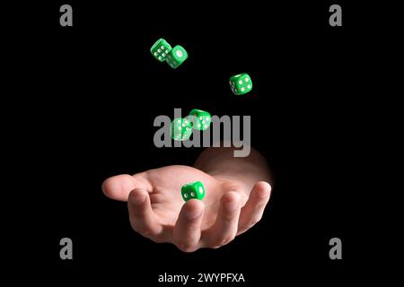 Man throwing green dice on black background, closeup Stock Photo