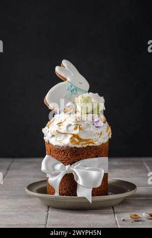 Easter cake on a dark background decorated with Easter chocolate eggs and Easter gingerbread rabbit Stock Photo