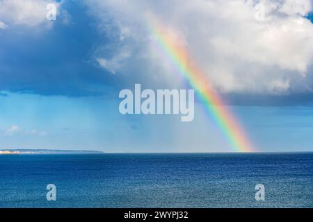 Rainbow over the Atlantic Ocean in Algarve, Portugal. Stock Photo