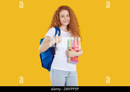 Portrait of smiling student woman with backpack and books Stock Photo