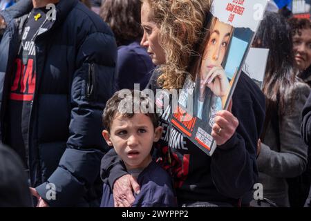 A mother holds her son as they stand and watch the rally, she is holding a poster for hostage Agam Berger. Thousands of people gathered in Dag Hammarskold Plaza to call for immediate release of the remaining 133 hostages in Gaza. Hostages were taken six months ago when Hamas attacked Israel on October 7th, 2023. Among those present were hostages that have been released as well as family members of those still being held or killed. The rally was organized by The Hostages and Missing families Forum. (Photo by Syndi Pilar/SOPA Images/Sipa USA) Stock Photo
