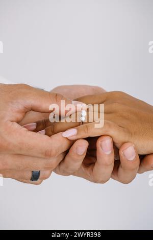 Man placing engagement ring on woman's finger Stock Photo