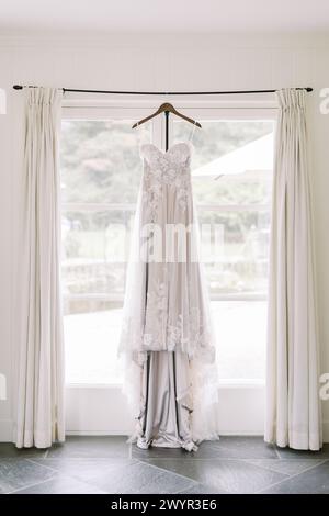Wedding dress on hanger in bright room Stock Photo
