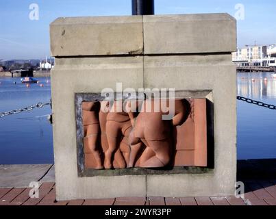 Terracotta panel showing rugby players designed by Martin Williams on the base of street lamp in Cardiff Bay to illustrate an aspect of Welsh culture Stock Photo
