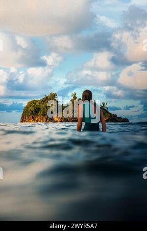 Girl sitting on surfboard waiting waves Stock Photo