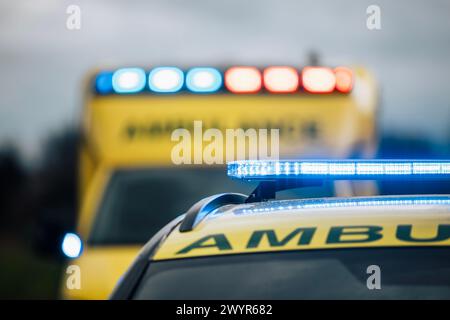 Close-up of blue light flasher on roof of ambulance car of emergency medical service on road. Themes rescue, urgency and health care. Stock Photo