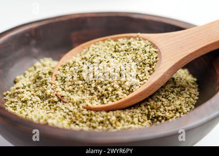 Wooden spoon with legal alimentary hemp seeds in rustic bowl close up Stock Photo