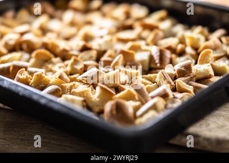 Baked pieces of rolls on a baking sheet, ready to make Karlovy Vary dumplings. Stock Photo