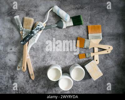 Various paint brushes, roller and paint samples on stone floor background Stock Photo
