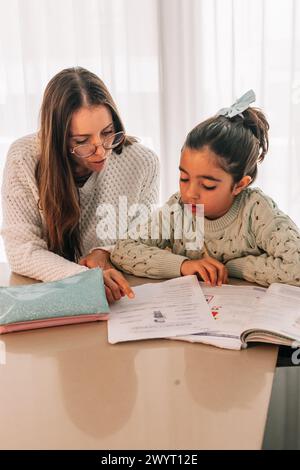 Mom helping her daughter with her school homework Stock Photo