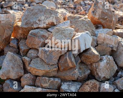 Stone wall of large mountain stones with burrs. A mountain of grey cobbles. Texture. Background. Horizontal Stock Photo