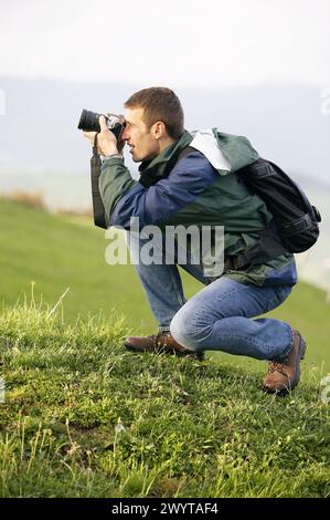 25 30 year old mountain climber taking pictures with digital SLR camera. Guipúzcoa, Euskadi, Spain. Stock Photo