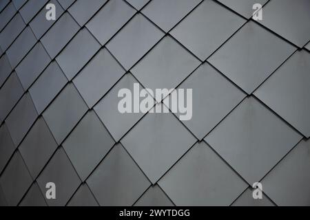 Gray weathered sheet metal diamond shaped roof tiles as background . Dark mood style Stock Photo
