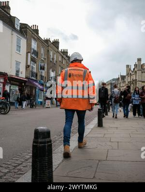 A construction worker in Safety gear in a town center Stock Photo