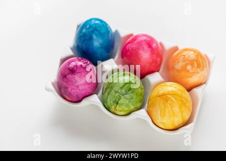 Assorted vibrant Easter eggs on white background, festive decoration Stock Photo