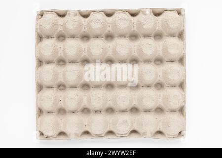 A top view of a beige egg carton displaying symmetrical circular indentations Stock Photo