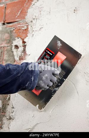Rendering a brick wall using trowel, new homes under construction, construction site. Stock Photo