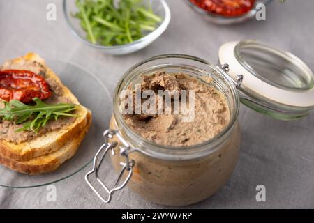 Chicken liver pate with wheat bread, arugula, sun-dried tomatoes and black tea. Homemade traditional rustic cuisine. Breakfast or snack option. Select Stock Photo
