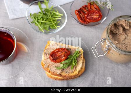 Chicken liver pate with wheat bread, arugula, sun-dried tomatoes and black tea. Homemade traditional rustic cuisine. Breakfast or snack option. Select Stock Photo
