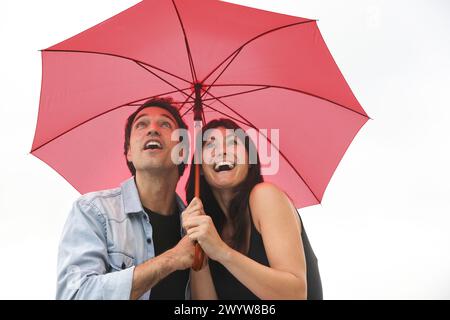 Couple in their 30´s smiling under umbrella. Stock Photo