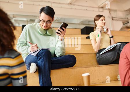 A multicultural group of students attentively listening in a lecture hall at a university. Stock Photo