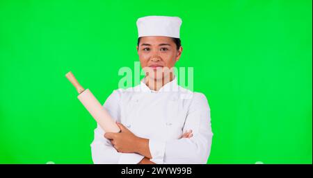 Green screen, baker and woman face with hand pointing and rolling pin in studio for checklist or info on mockup background. Portrait, chef and asian Stock Photo