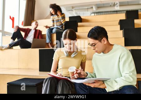 A multicultural couple peacefully sitting on stairs, engrossed in conversation in an indoor setting Stock Photo